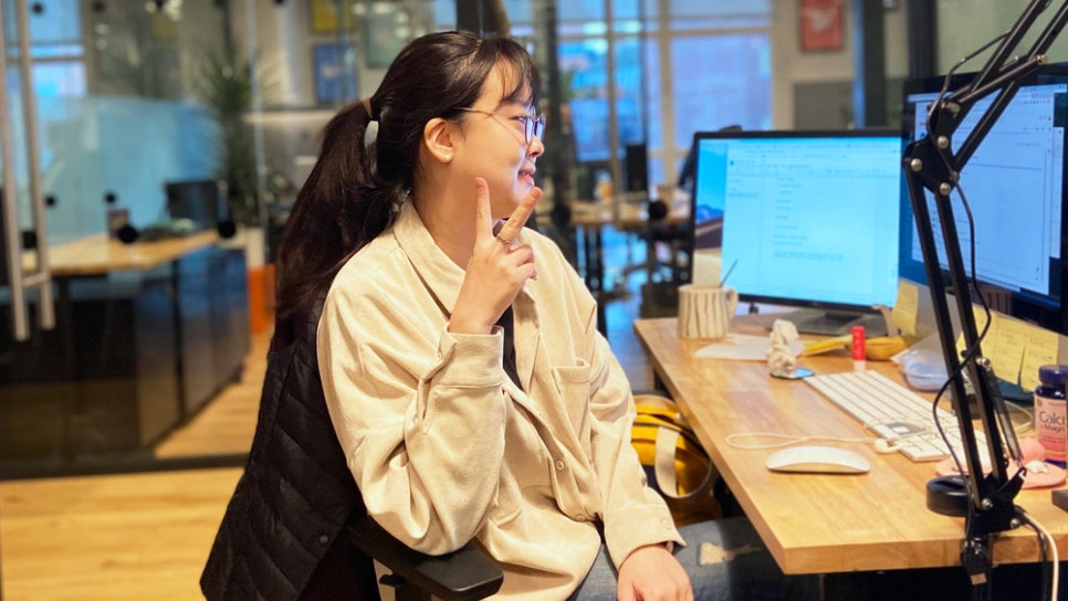 사무실 책상에서 마이크 앞에 앉아 이야기하는 사람